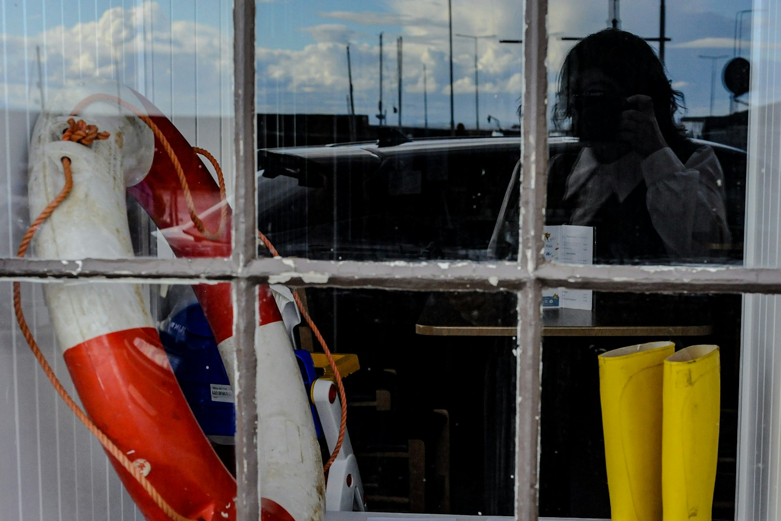 Life rings and yellow sea boots through the chandlery window