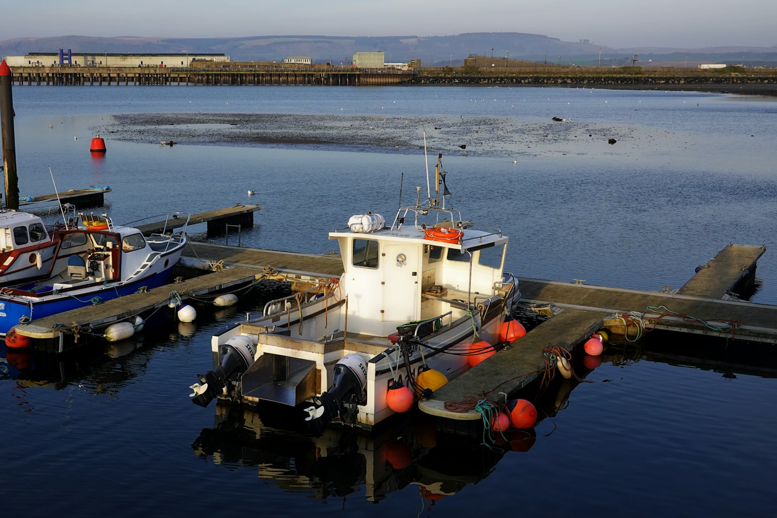 A small workboat on flat water off the pontoon