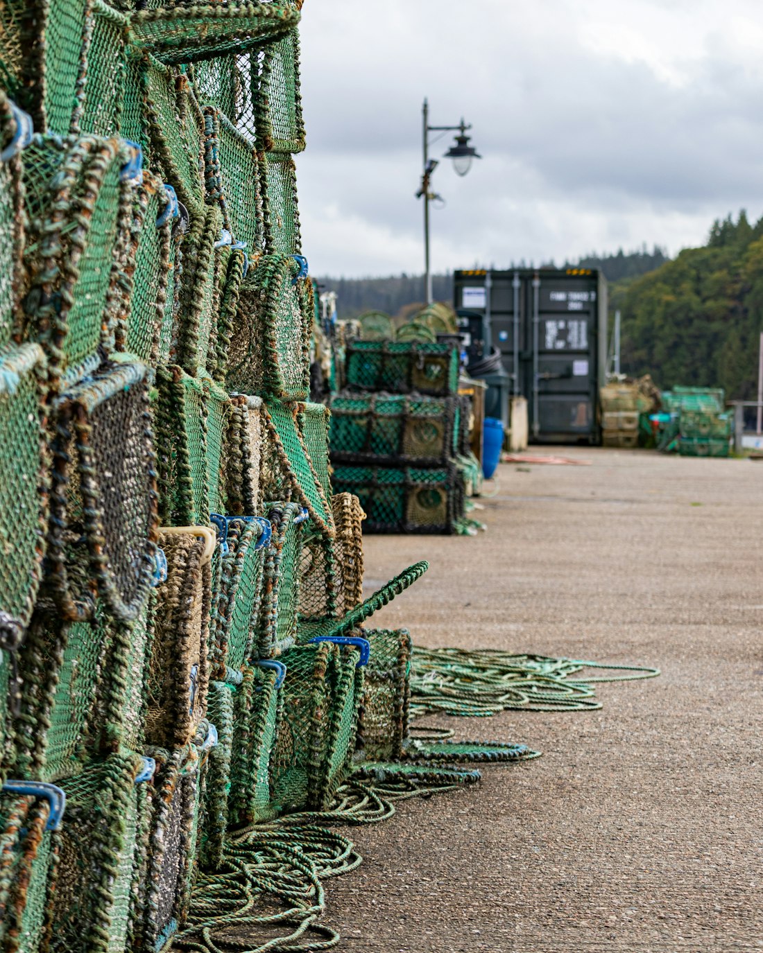 Creels stacked the length of the quay under a grey sky
