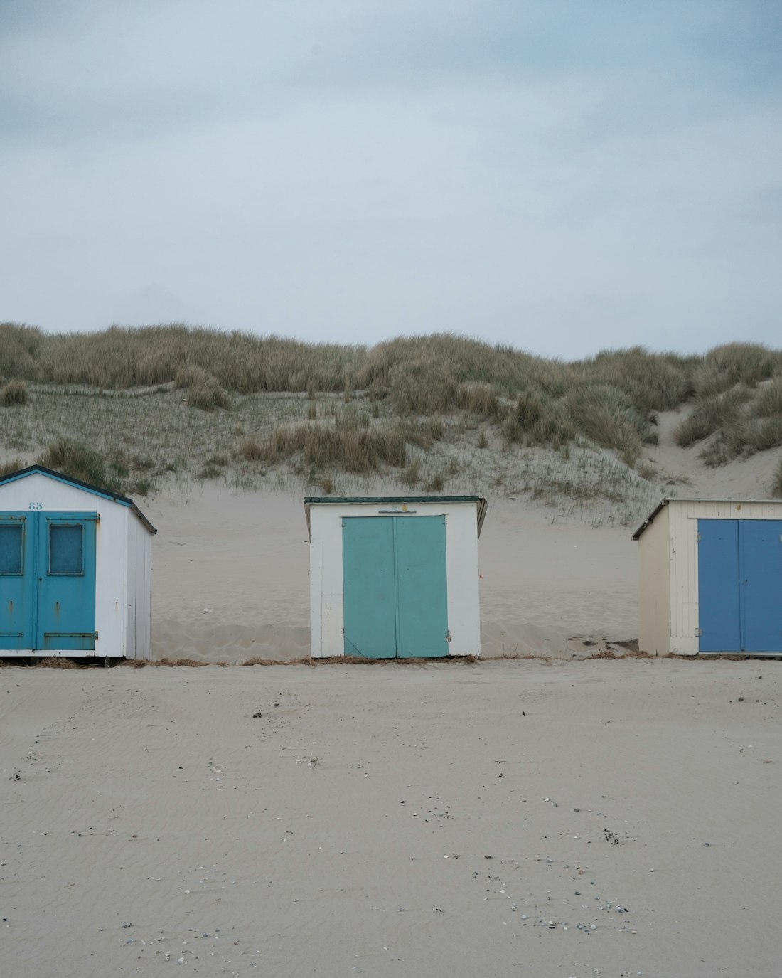 Beach huts shut for the winter below the dunes